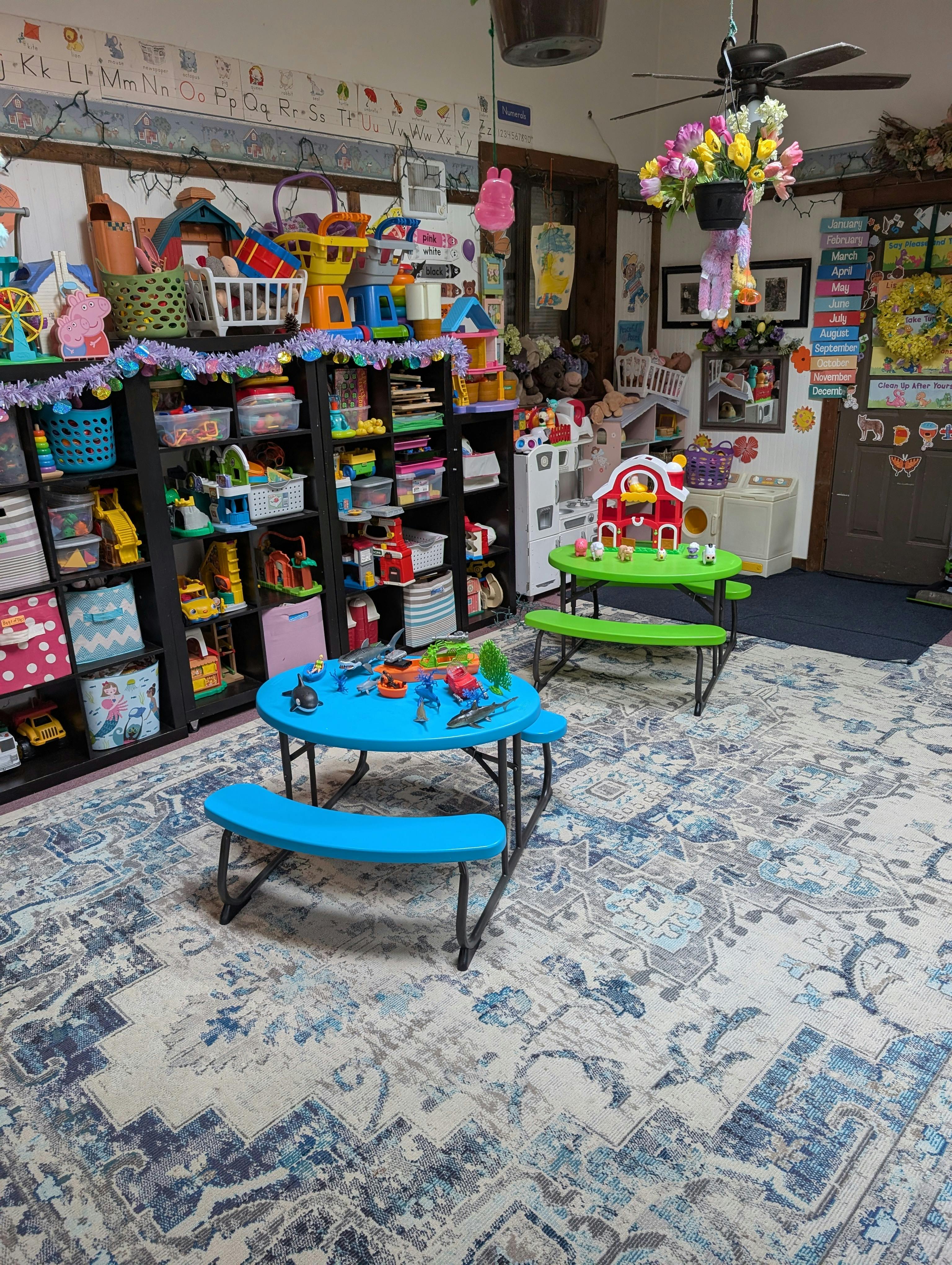 Classroom filled with shelves of toys, child-sized tables, and educational decorations