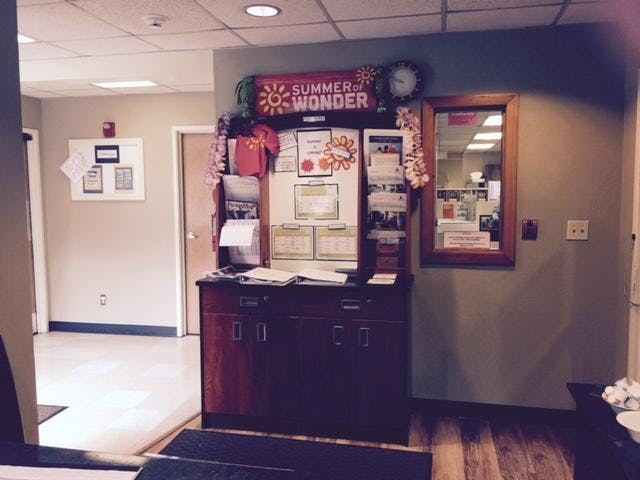 Cabinet with notice board and "Summer of Wonder" sign in an office