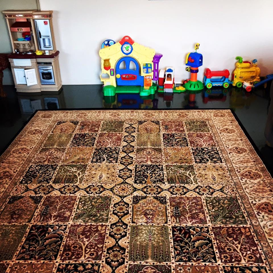 Patterned area rug with children's toys and play kitchen in background
