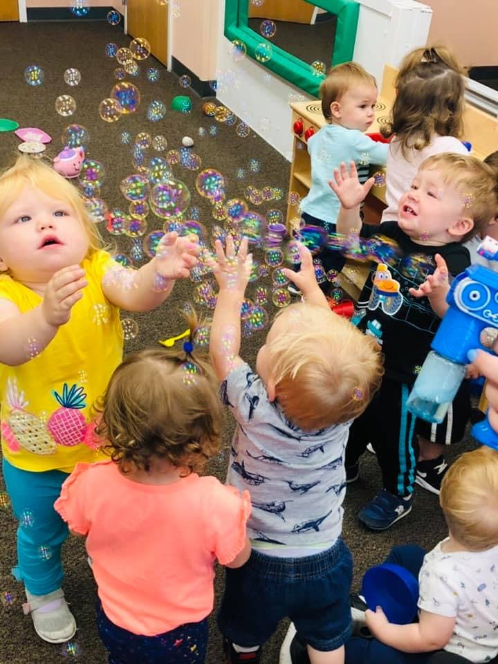 Children reaching for bubbles