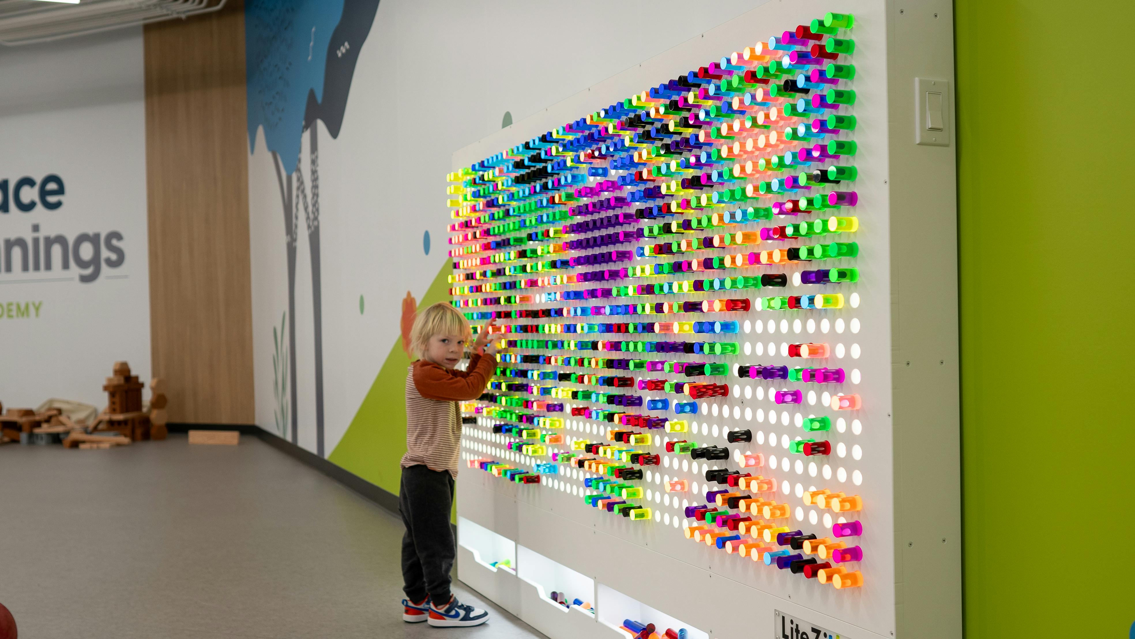 Child interacting with a large colorful light board