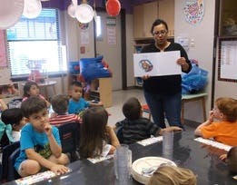 Adult showing children a drawing in a classroom