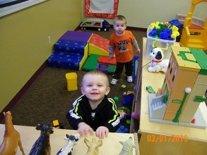 Two children playing in a room with toys