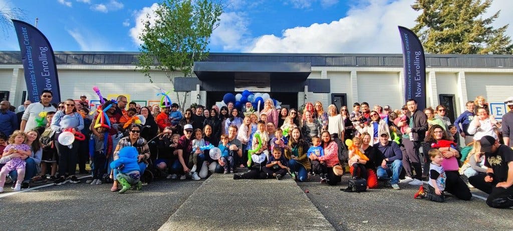 Large group of people and children gathered outdoors in front of a building