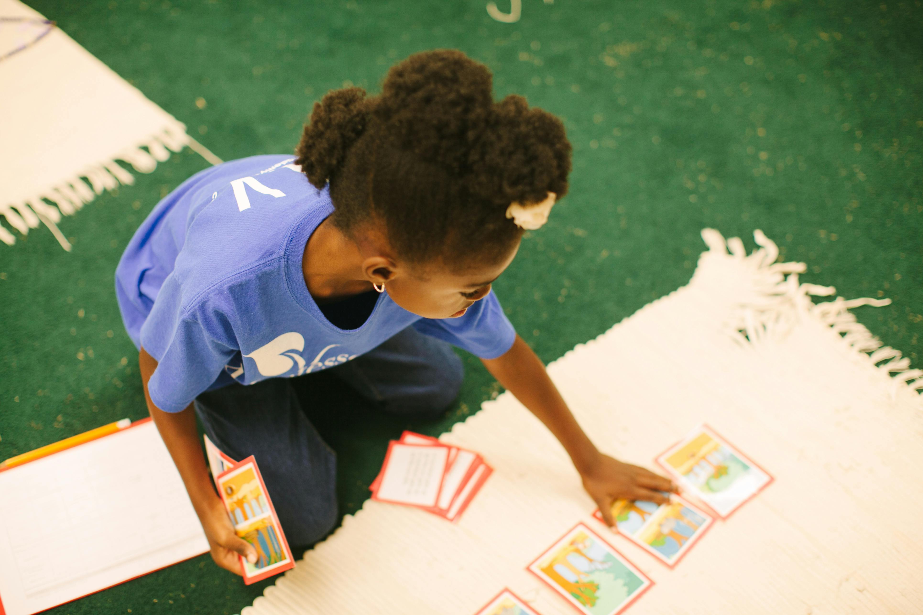 Child playing with cards on a rug