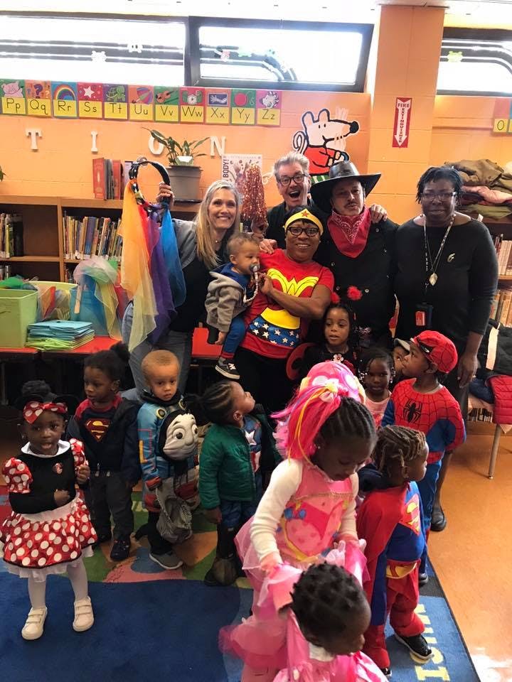 Adults and children in costumes posing for a photo