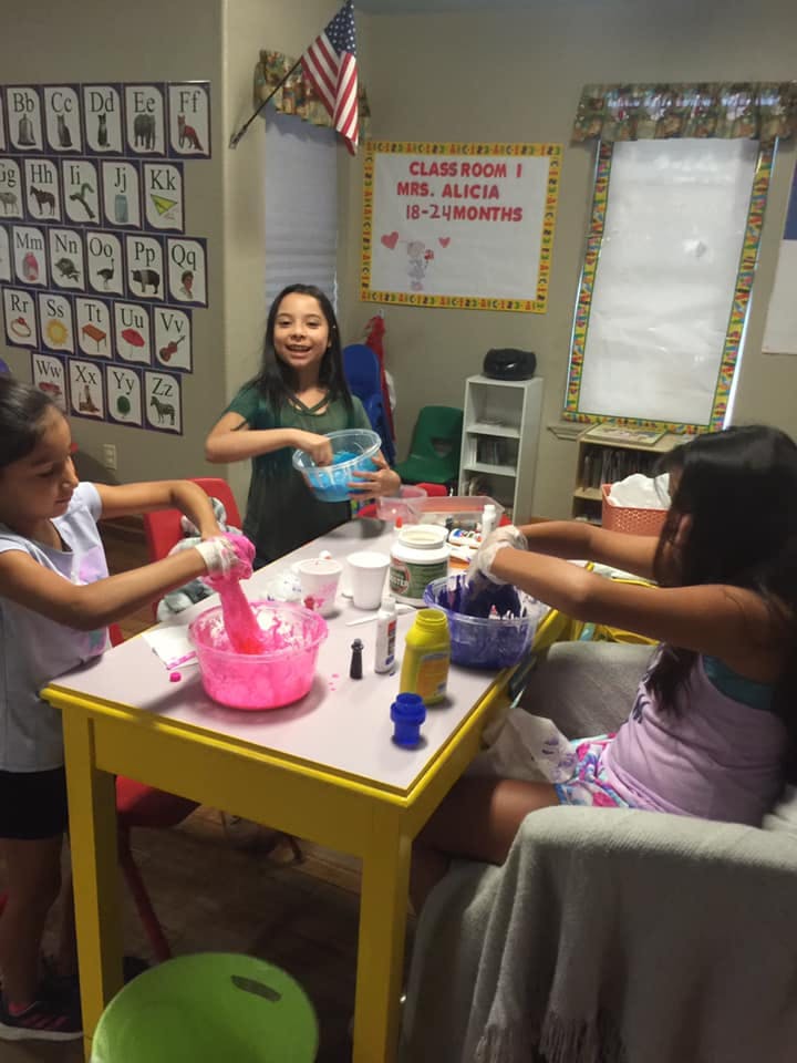 Three people making slime at a table in a classroom