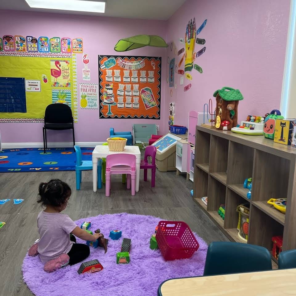 Child playing with toys on a purple rug in a classroom