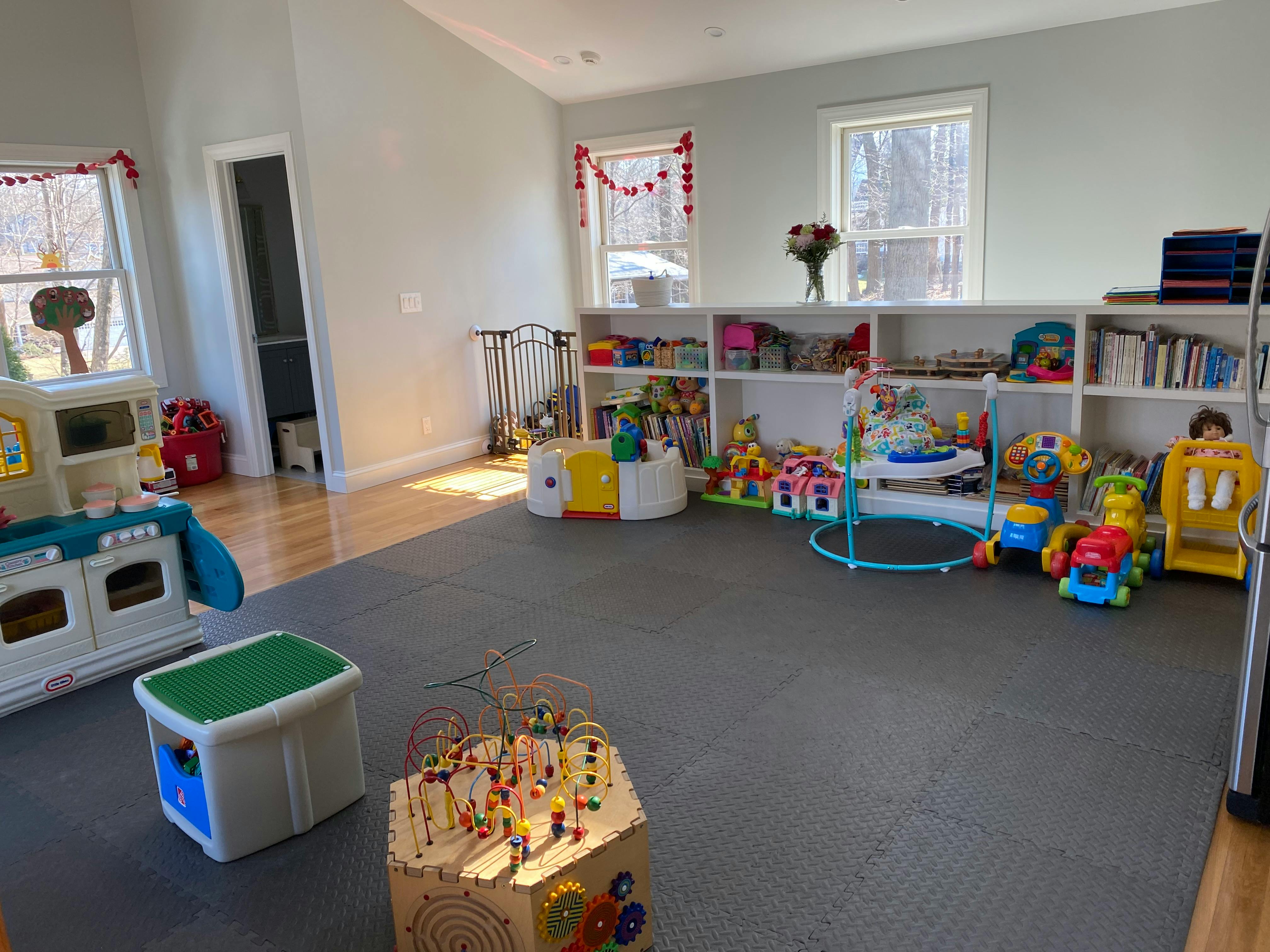 Playroom with various toys and shelves filled shelves