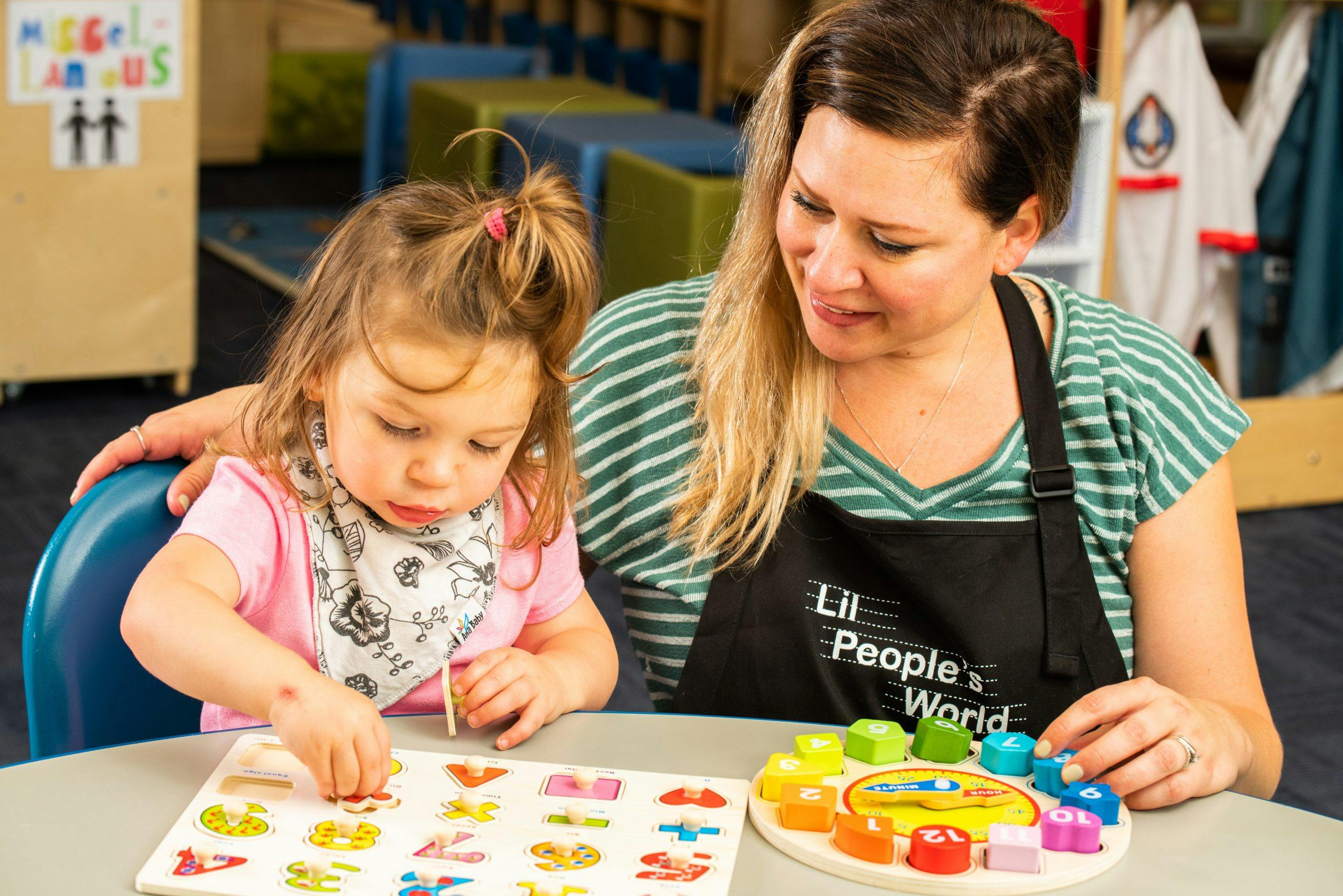 Adult and child playing with educational puzzles at a table