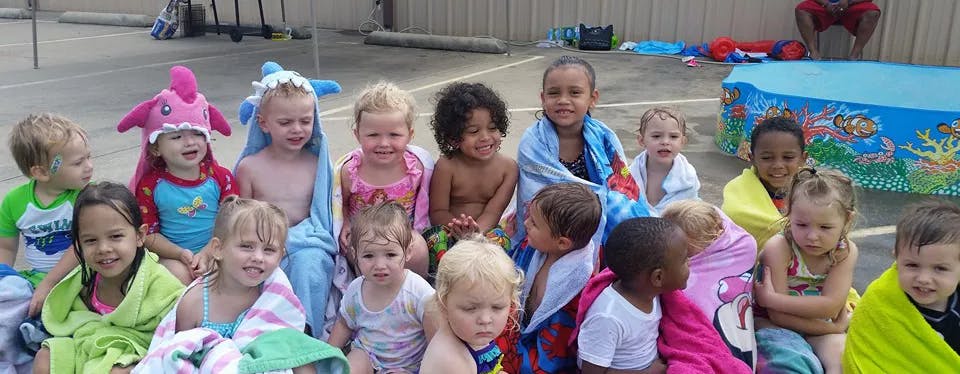 Group of children wrapped in towels sitting together
