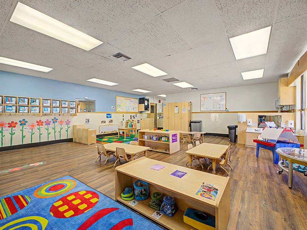 Empty children's classroom with small tables and chairs