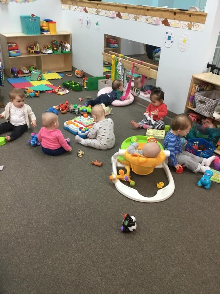Multiple children playing with toys in a classroom