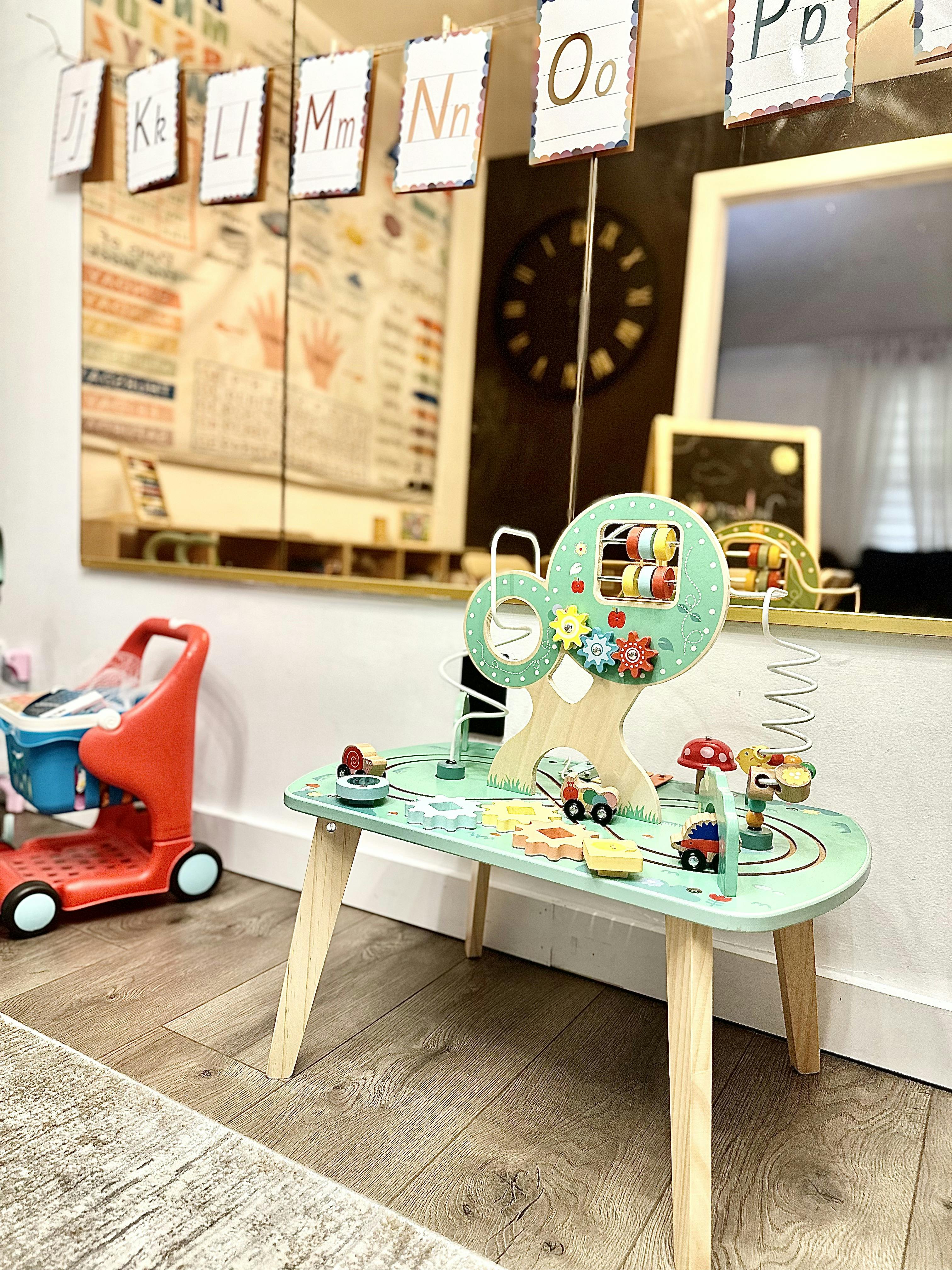 Children's play table with a toy car track and activity tree