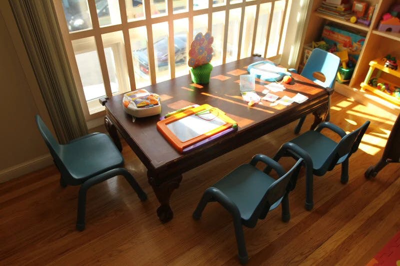 Small table with chairs and toys in front of a window