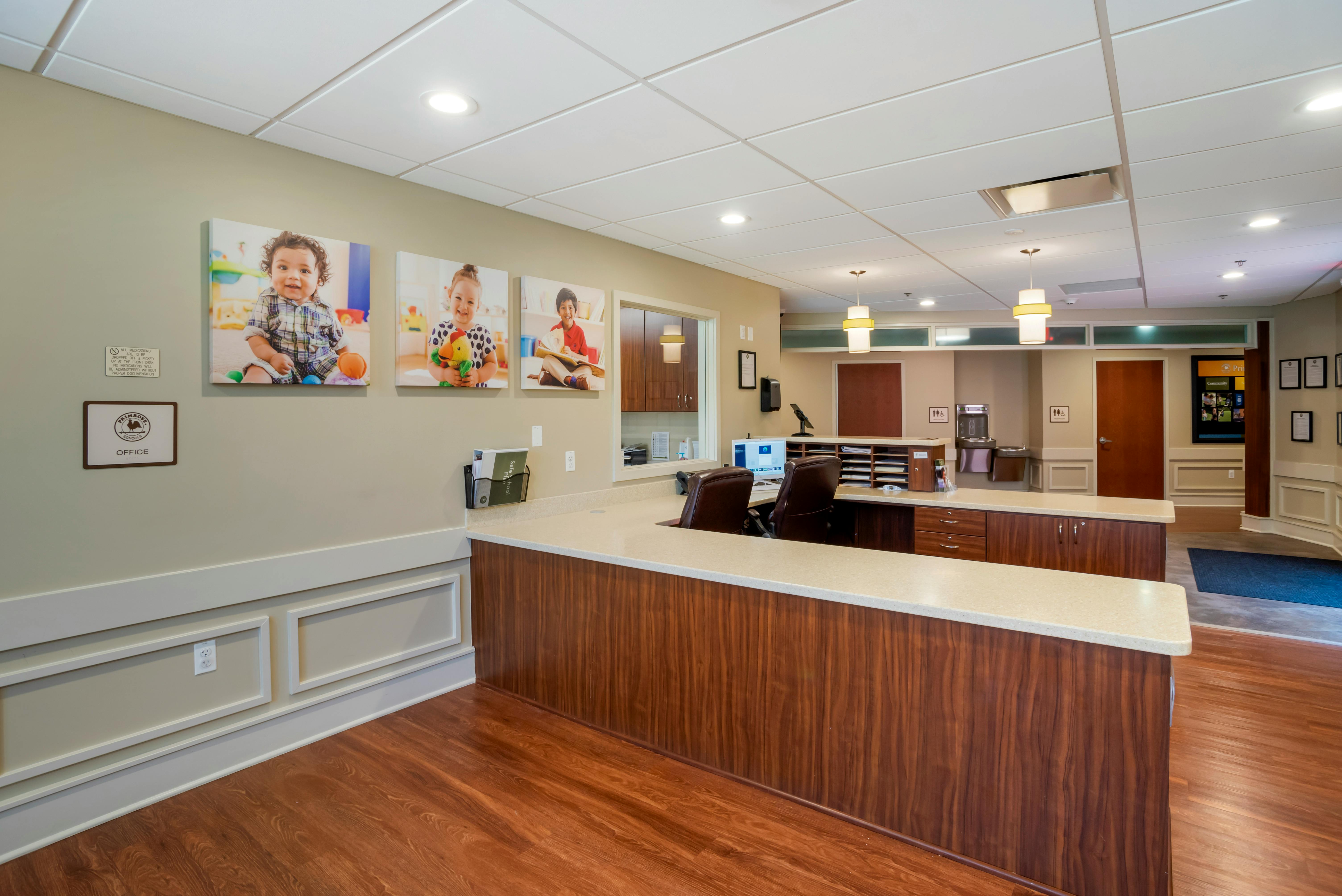 Reception desk with three large photos of children on the wall