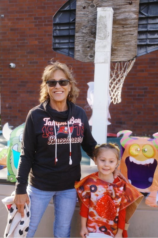 Adult and child in a pizza costume standing by a basketball hoop
