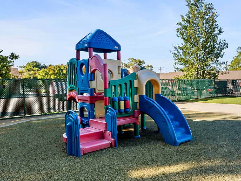 Playground equipment with slide and stairs on a green surface