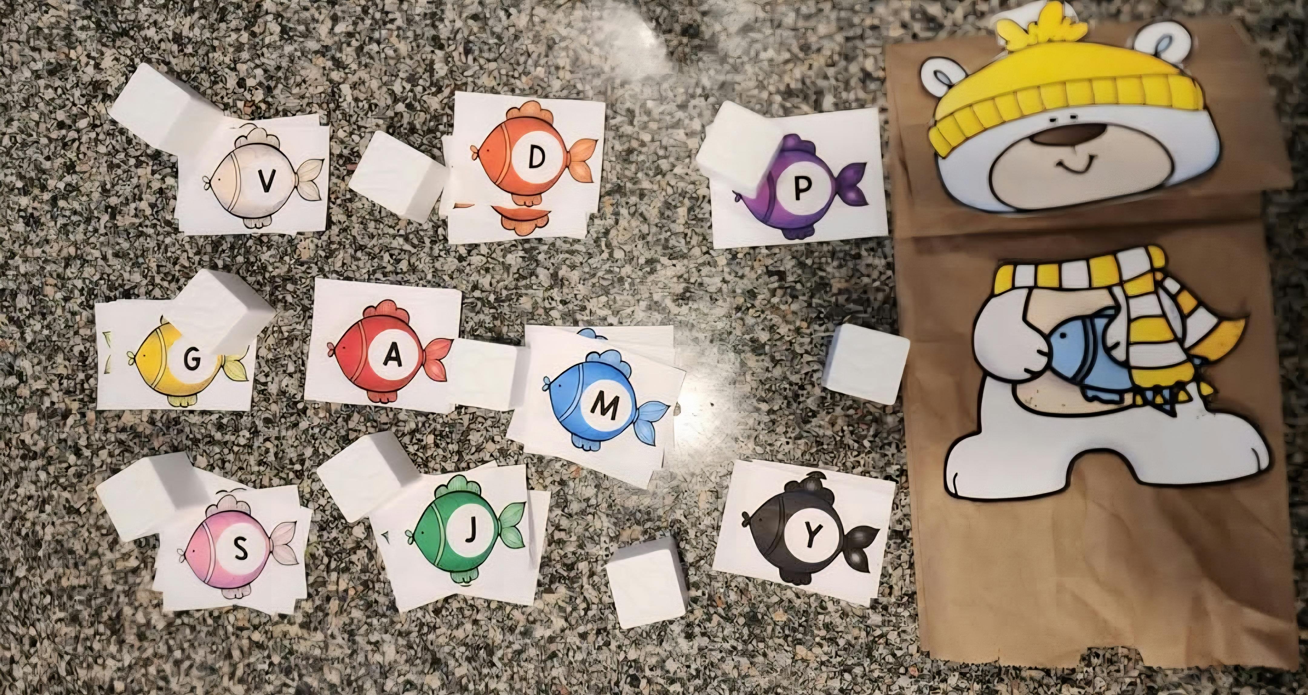 Cards with lettered fish illustrations and a bear cutout on a paper bag