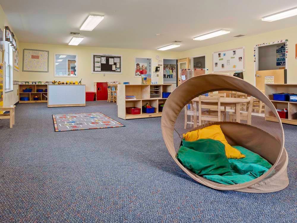 Empty classroom with a fabric reading nook in the foreground