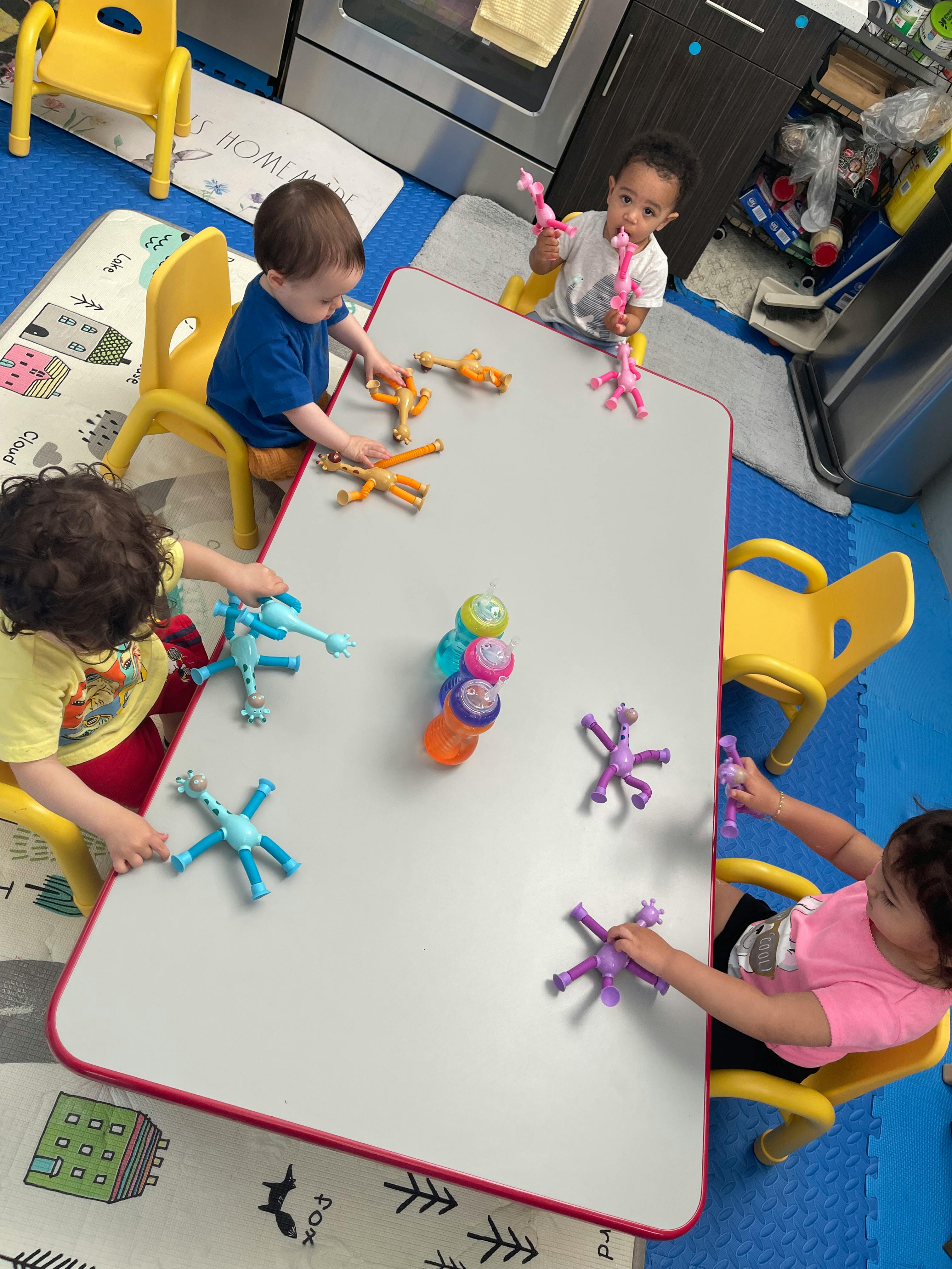 Four children playing with toys at a table