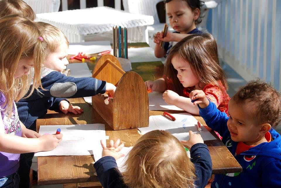 Children drawing with crayons at a table