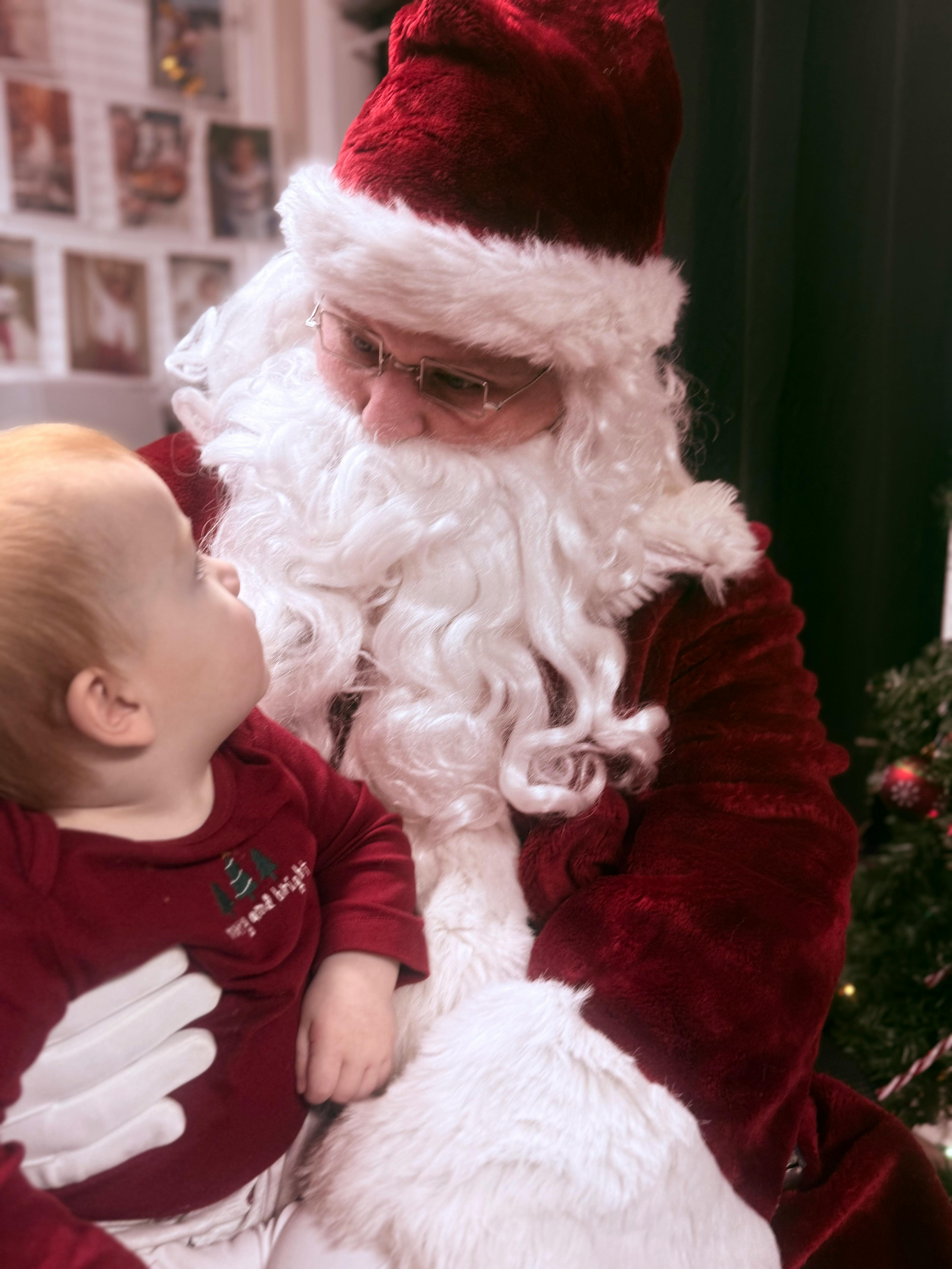 Person dressed as Santa Claus holding a child