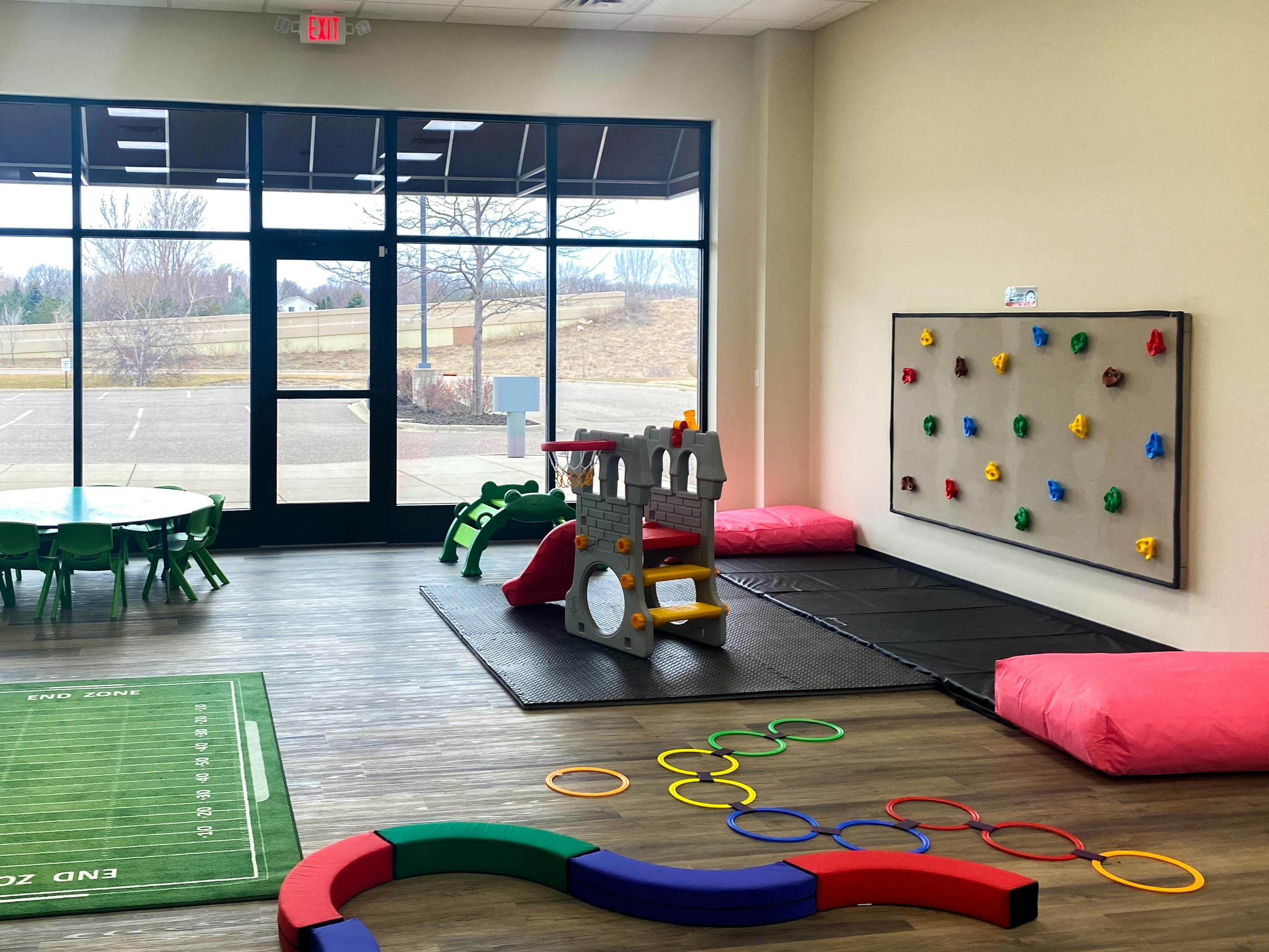 Indoor play area with climbing wall, slide, and floor toys