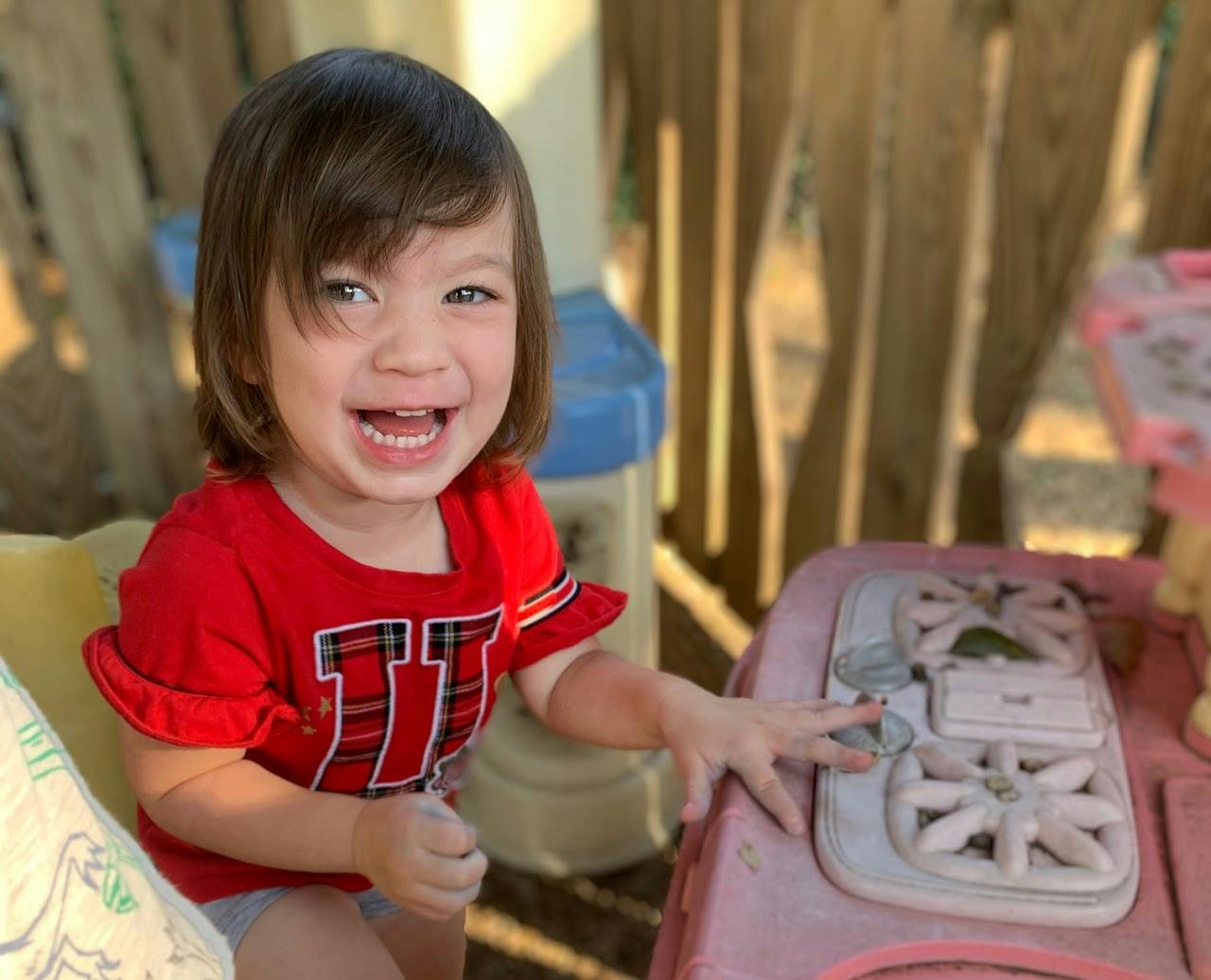 Child in red shirt playing with a toy stove