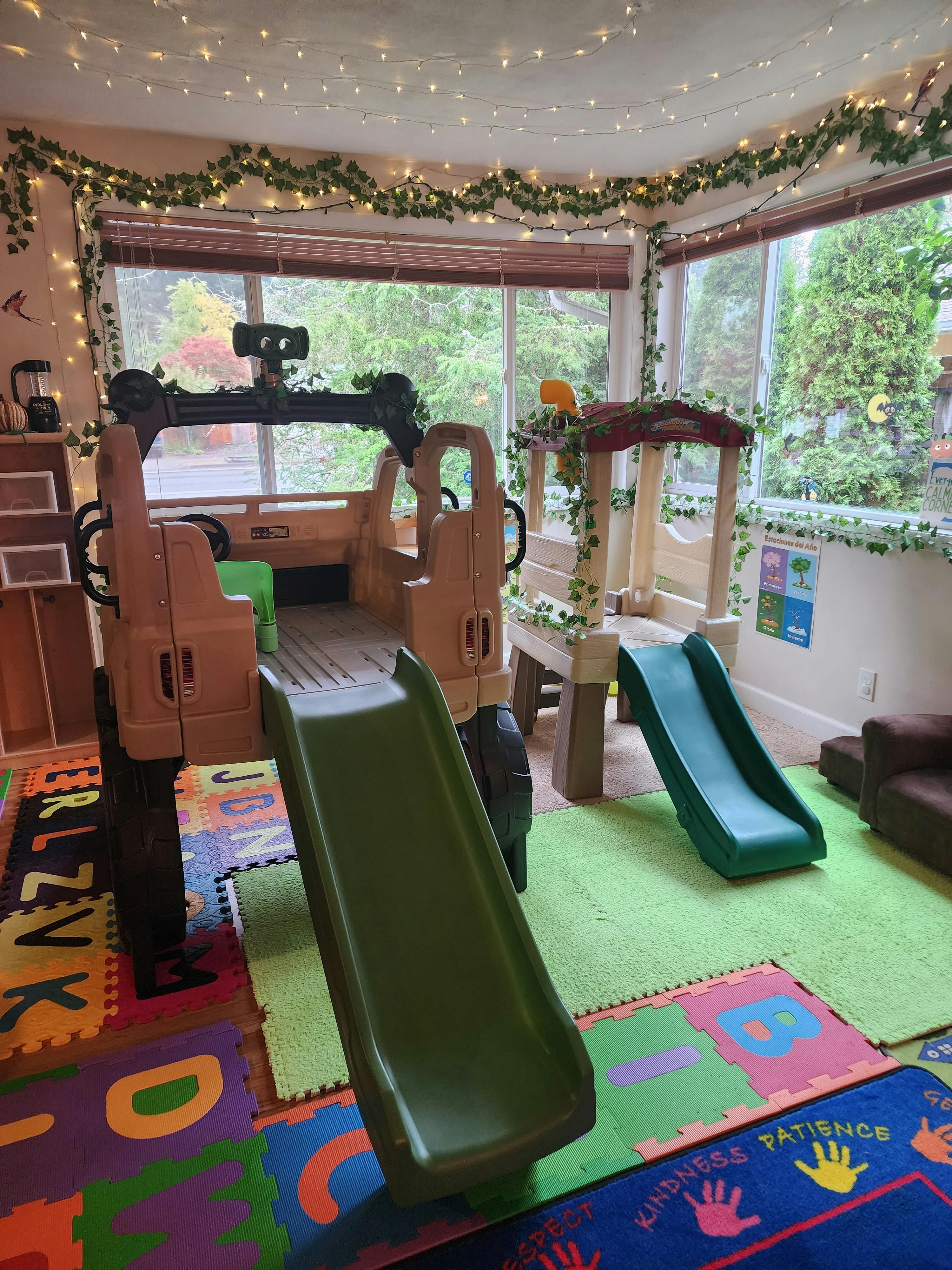 Indoor play area with two slides and a play structure