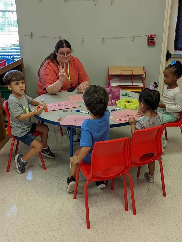 Person and children at a table in a classroom