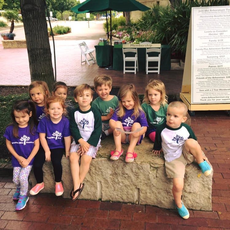 Group of children sitting on a stone ledge outdoors
