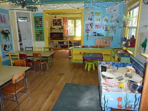 Classroom with tables, chairs, and a sand table