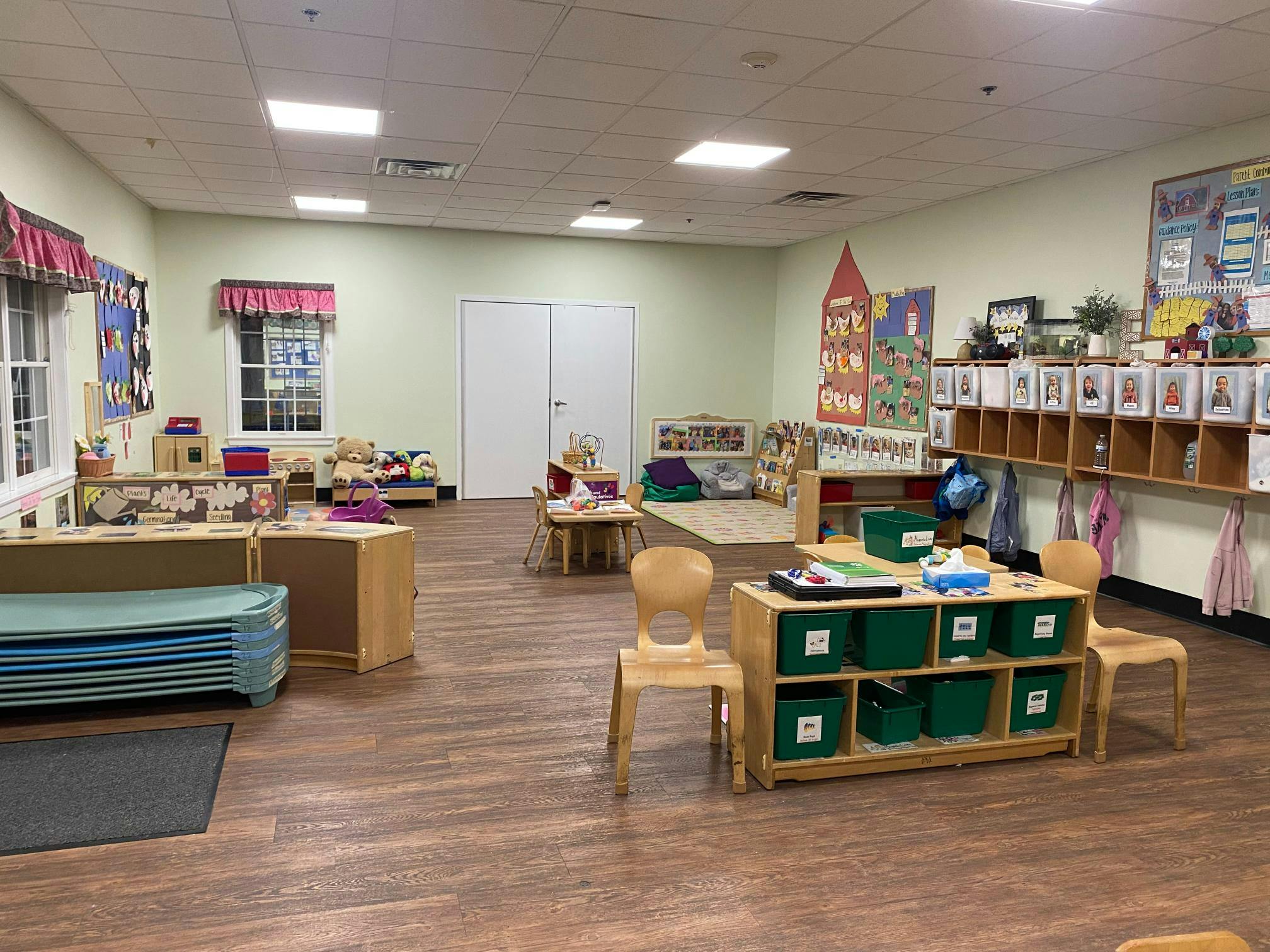 Empty classroom with children's furniture, shelves with cubbies, and decorations