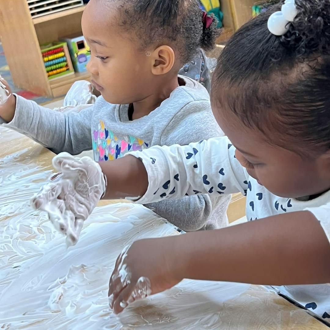 Two children playing with white dough or flour