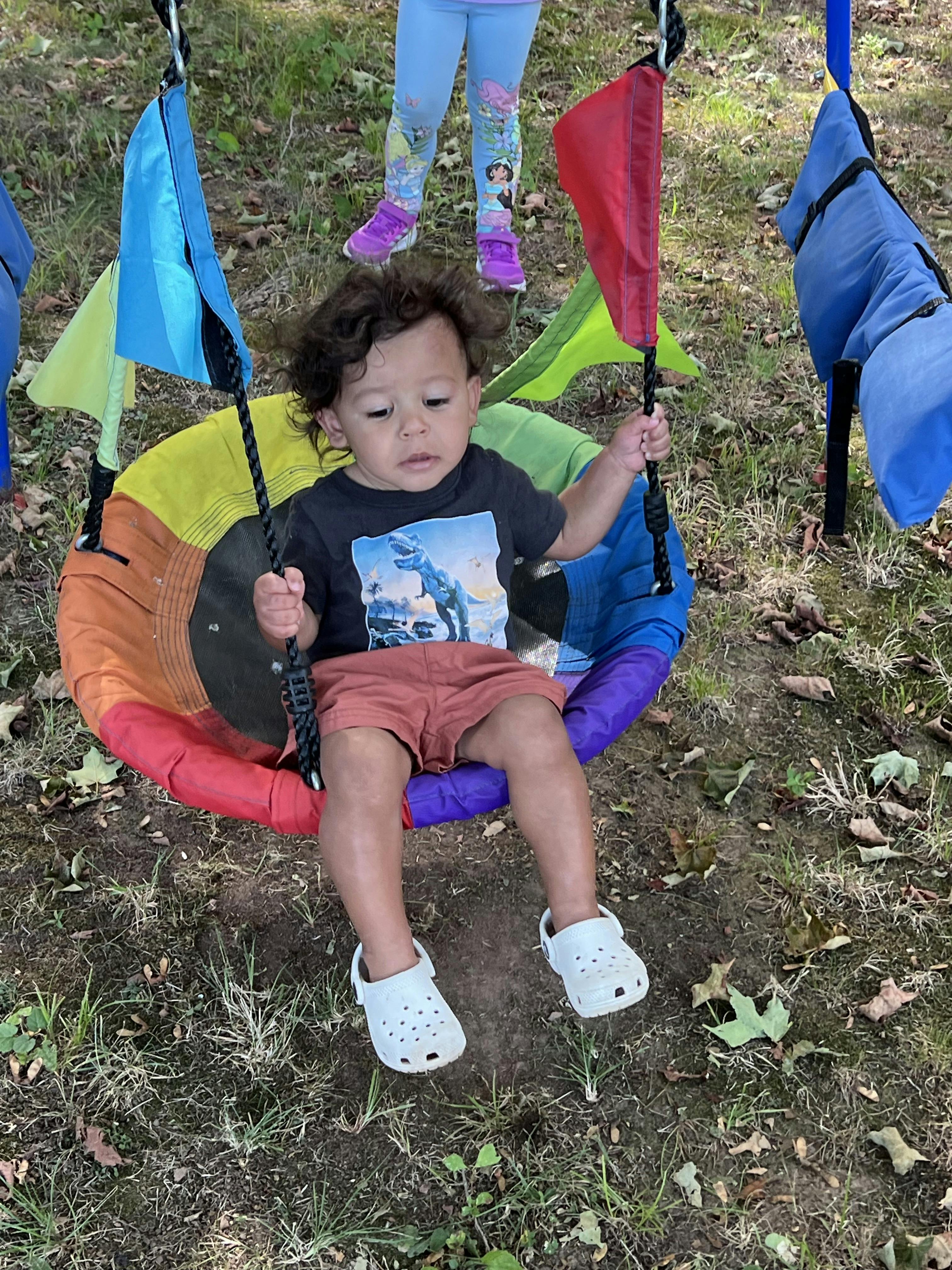 Child sitting in a colorful swing