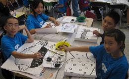 Children painting at a table in a classroom