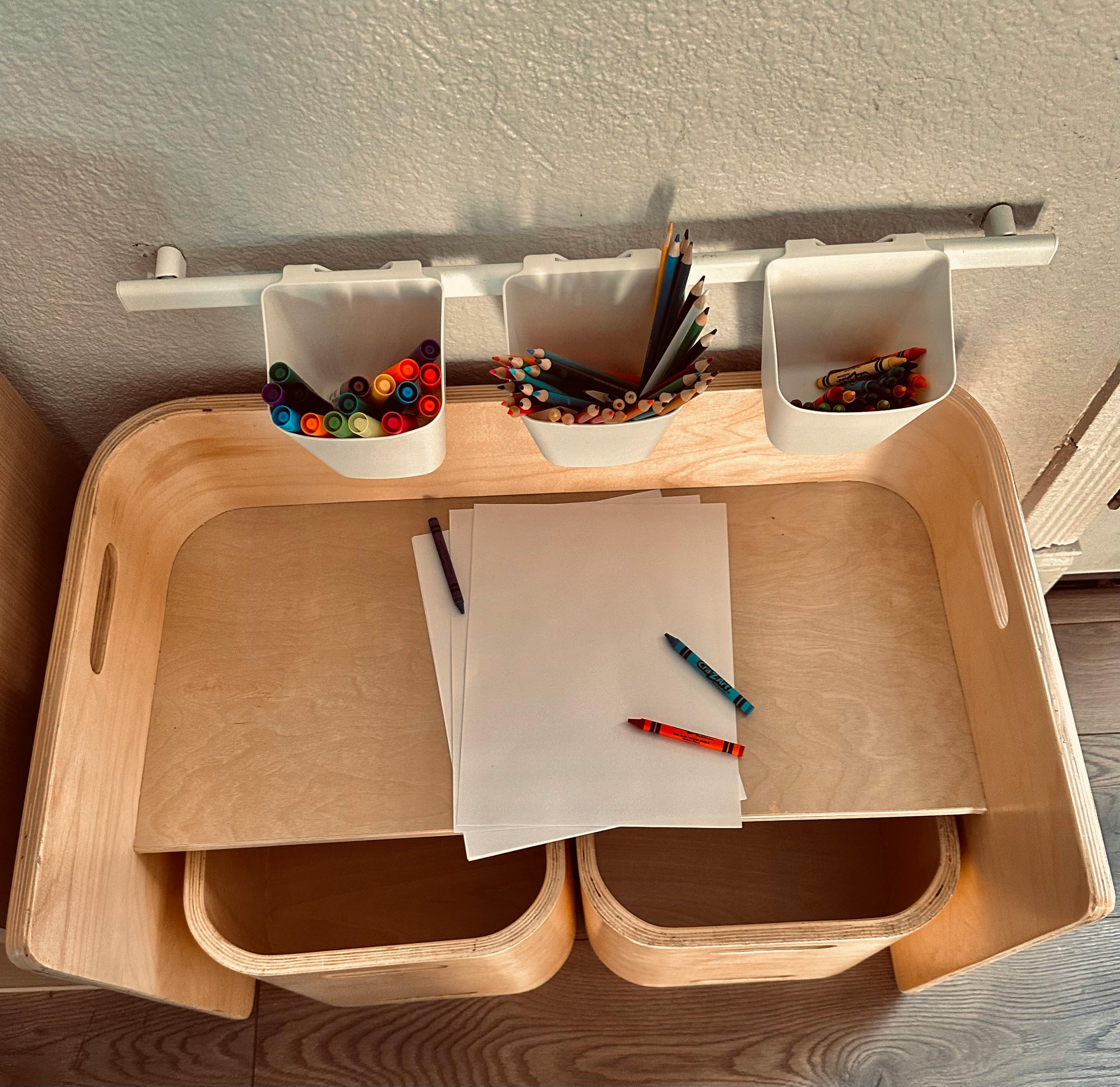Children's art desk with paper, crayons, markers, and colored pencils