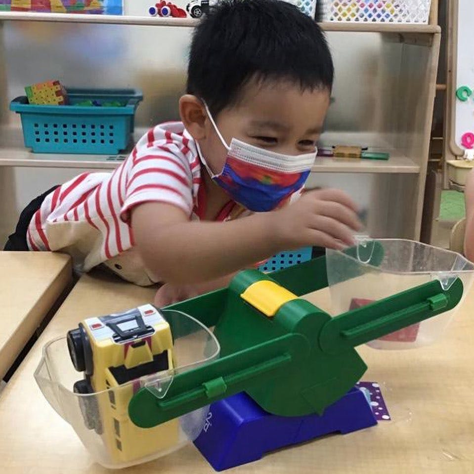 Child in mask playing with a scale