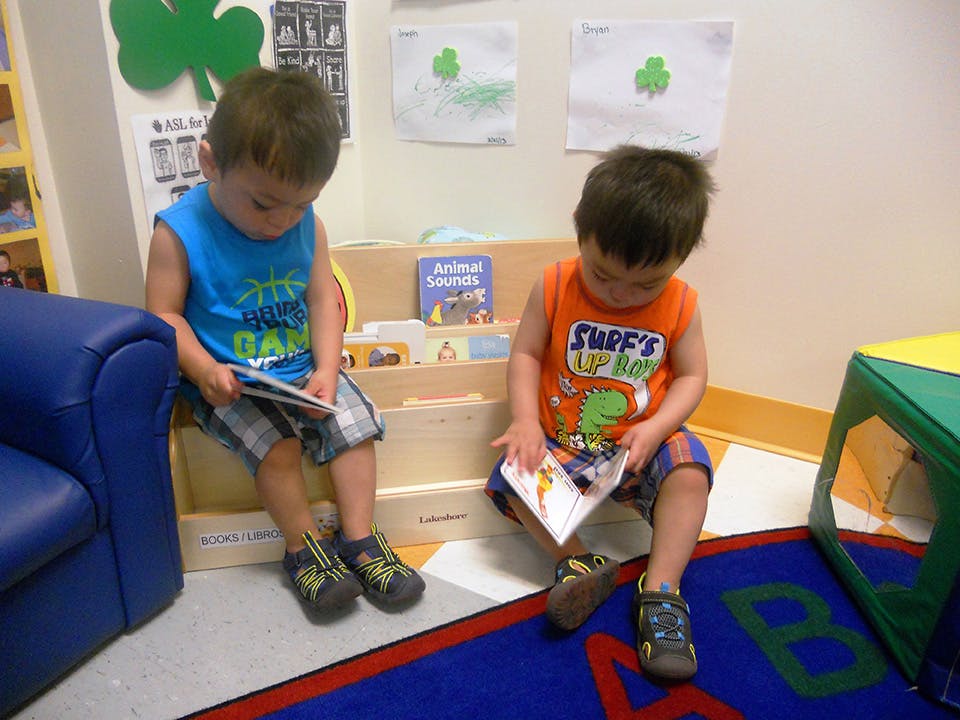 Two children sitting and looking at books