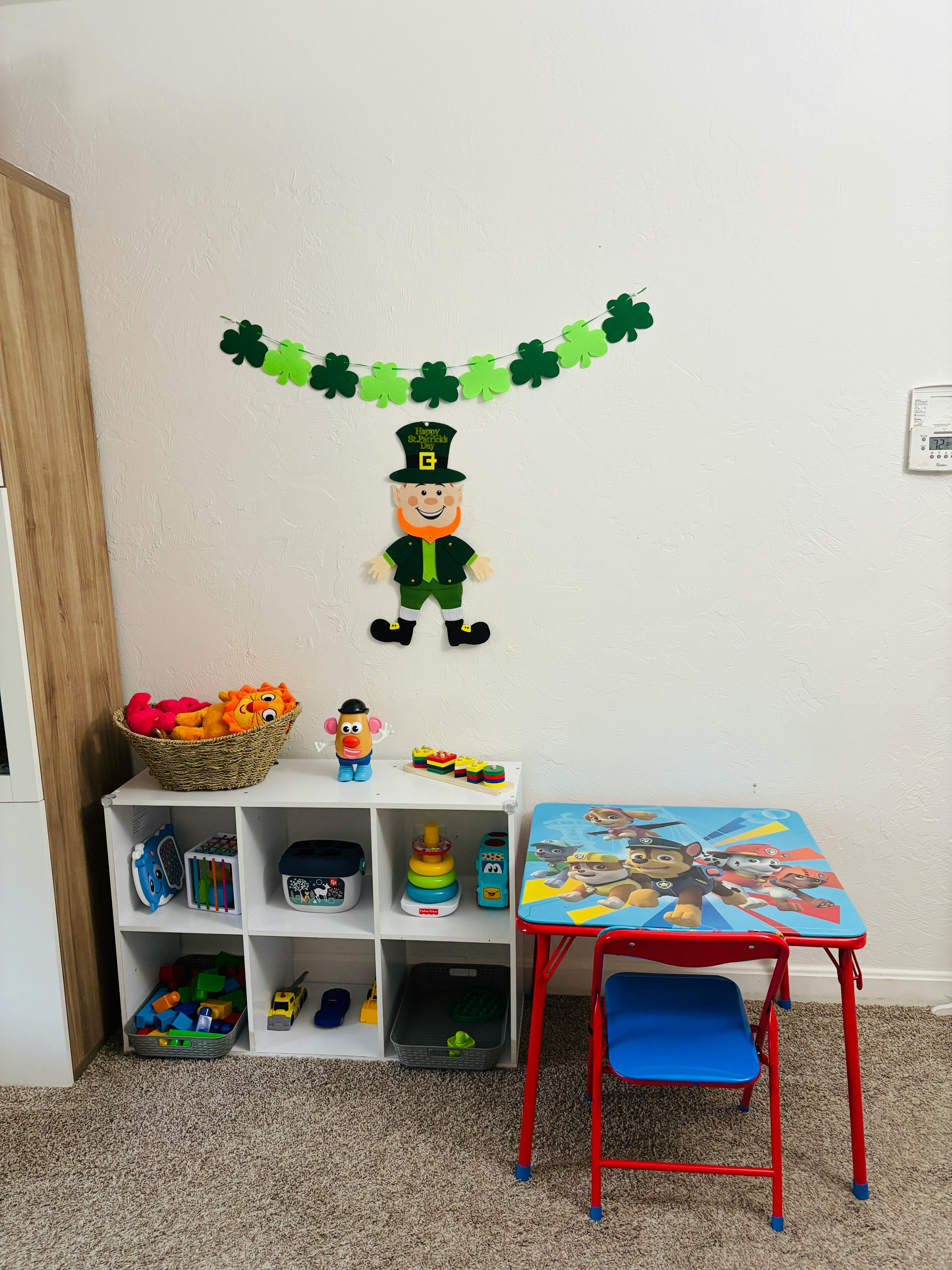 Playroom with a small table and chair, toy storage, and St. Patrick's Day decorations