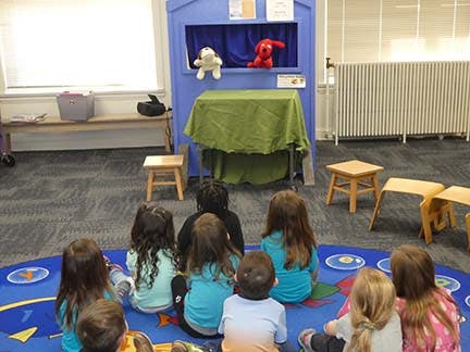Children watching a puppet show in a classroom