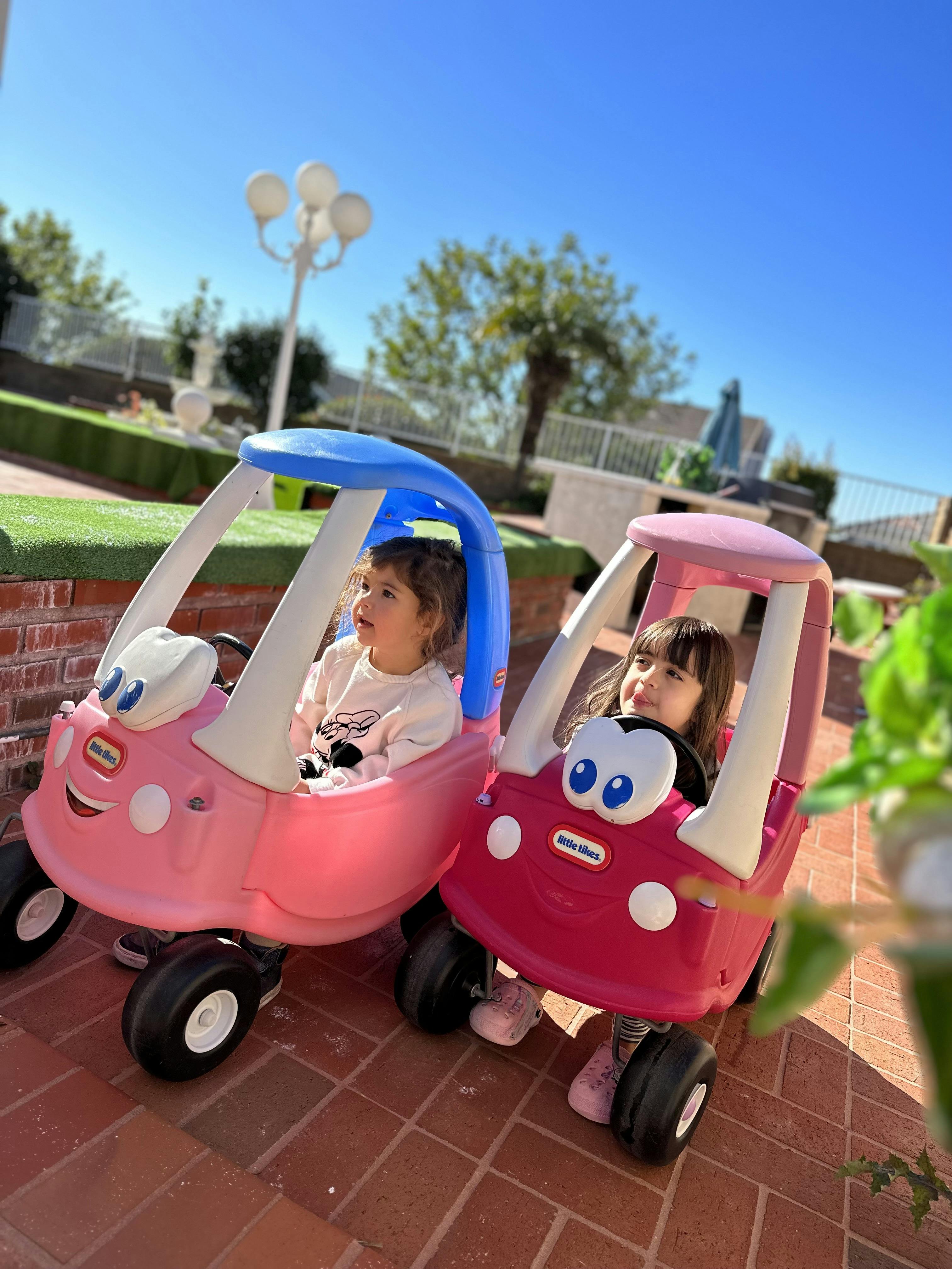 Two children in toy cars
