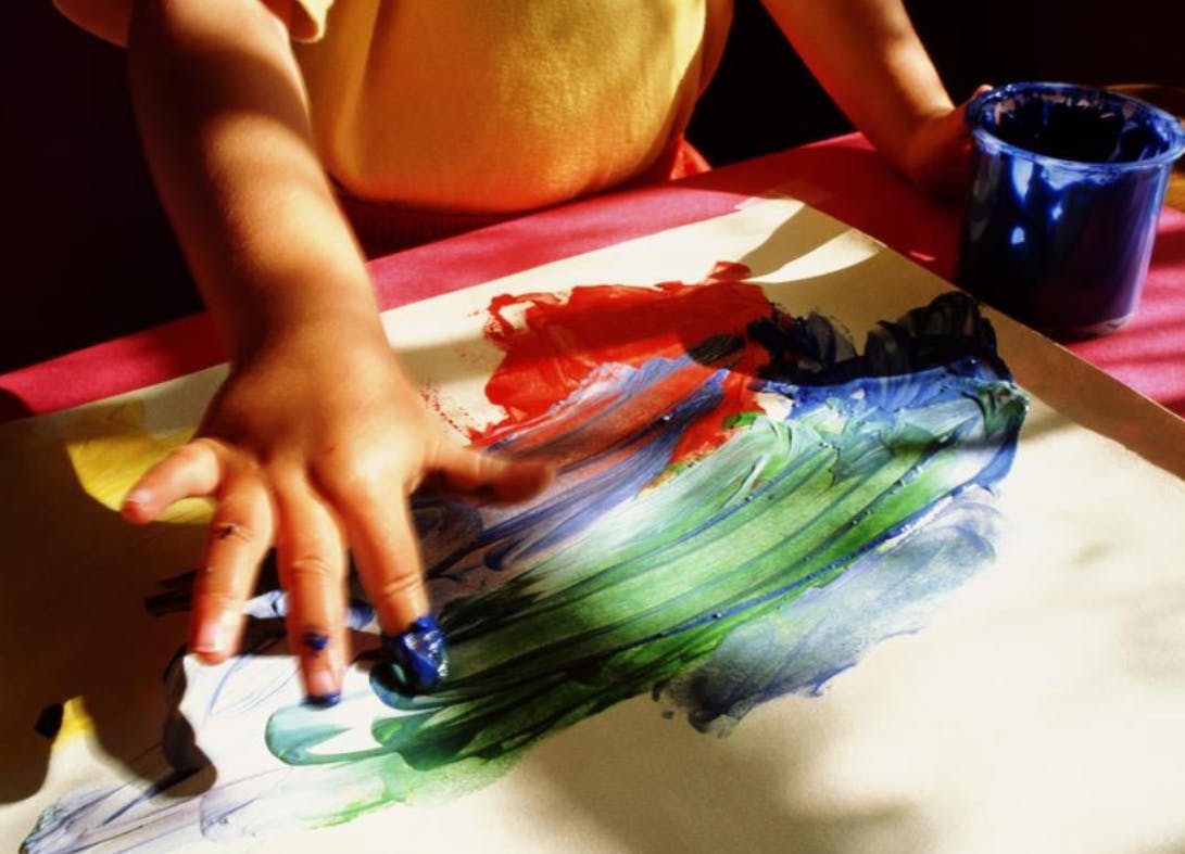 Child finger painting on paper
