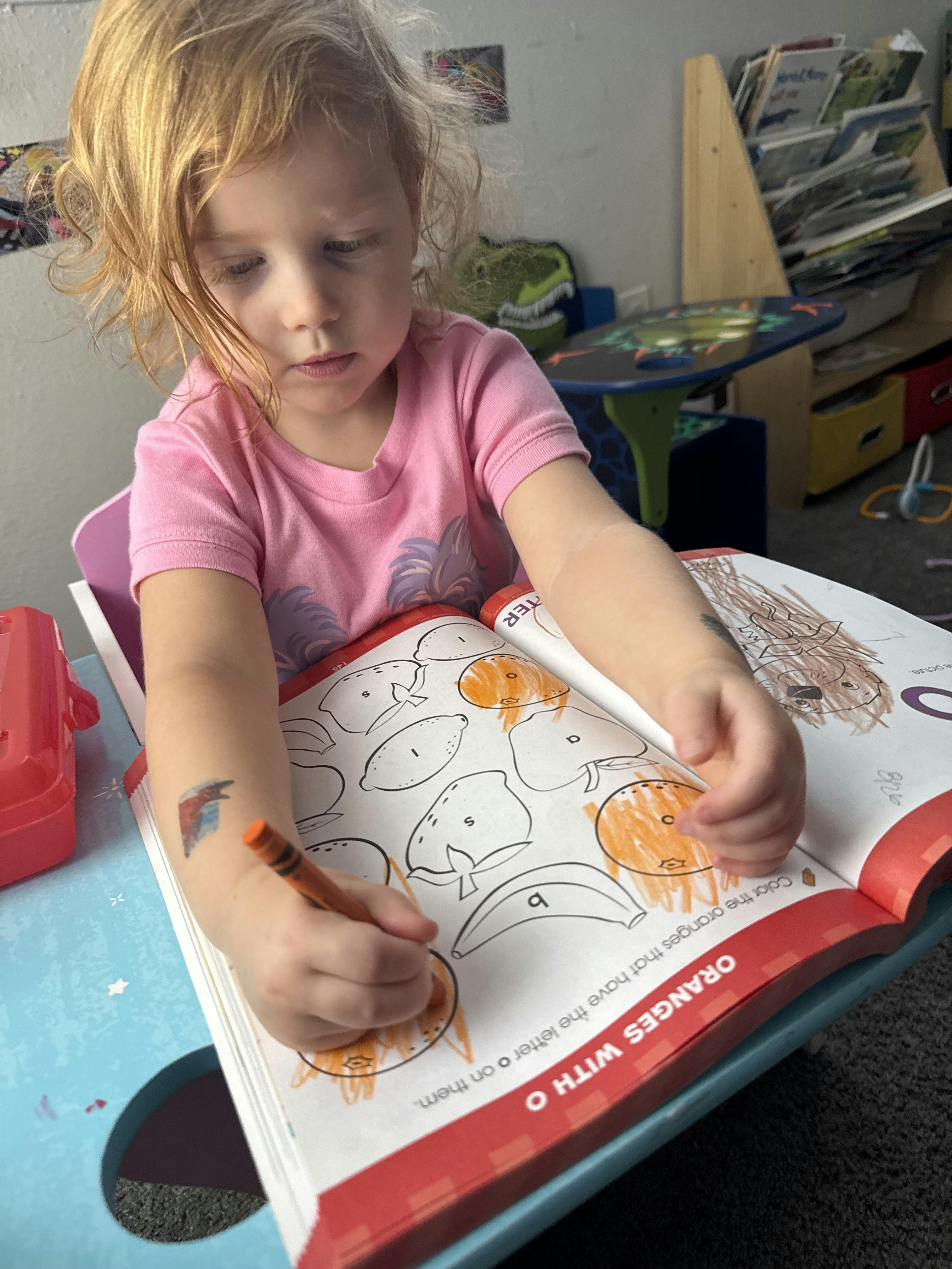 Child coloring in a book with a crayon