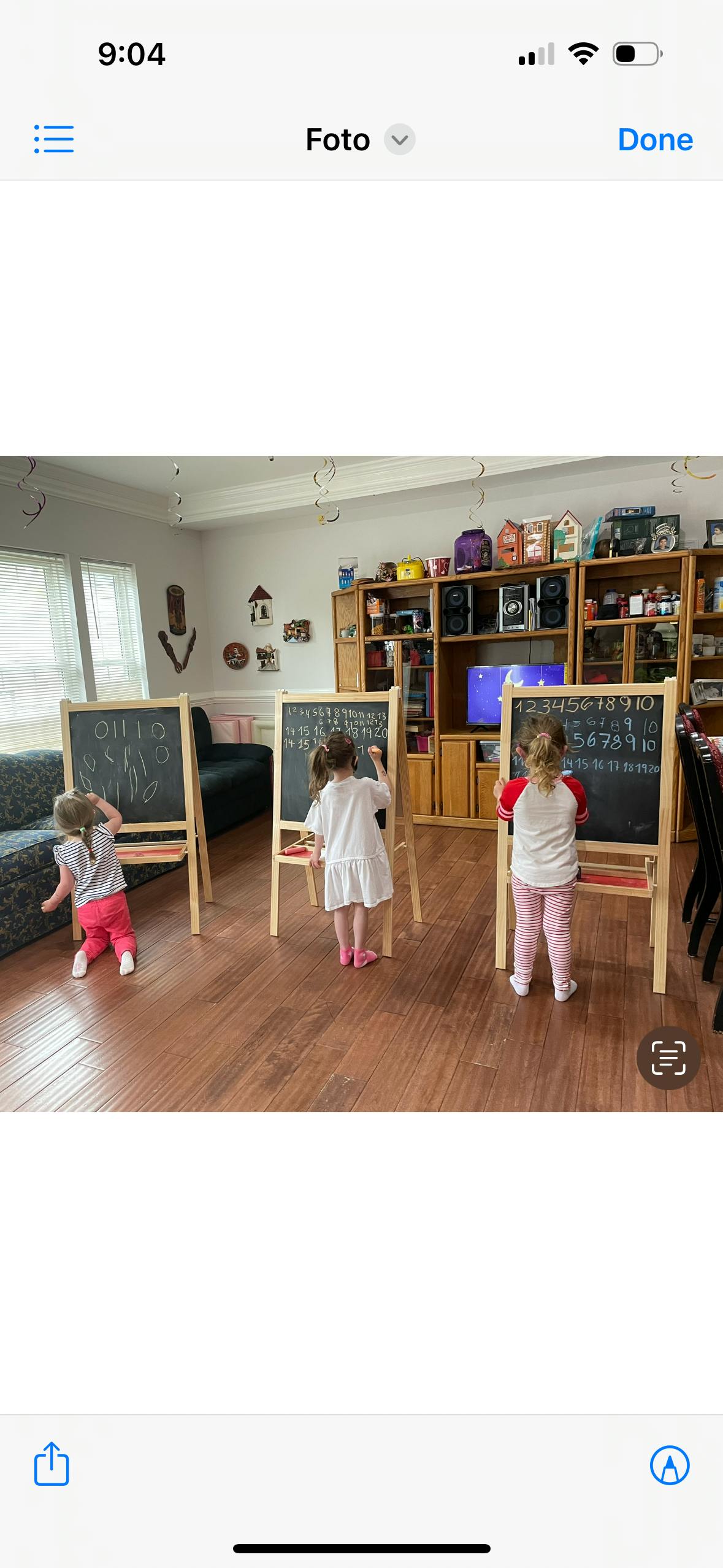 Three children drawing on chalkboards in a room