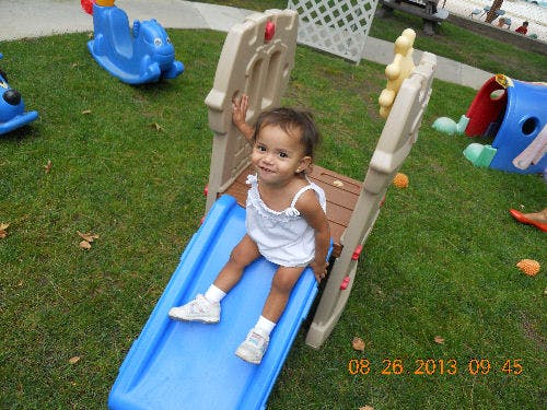 Child sitting on a blue slide