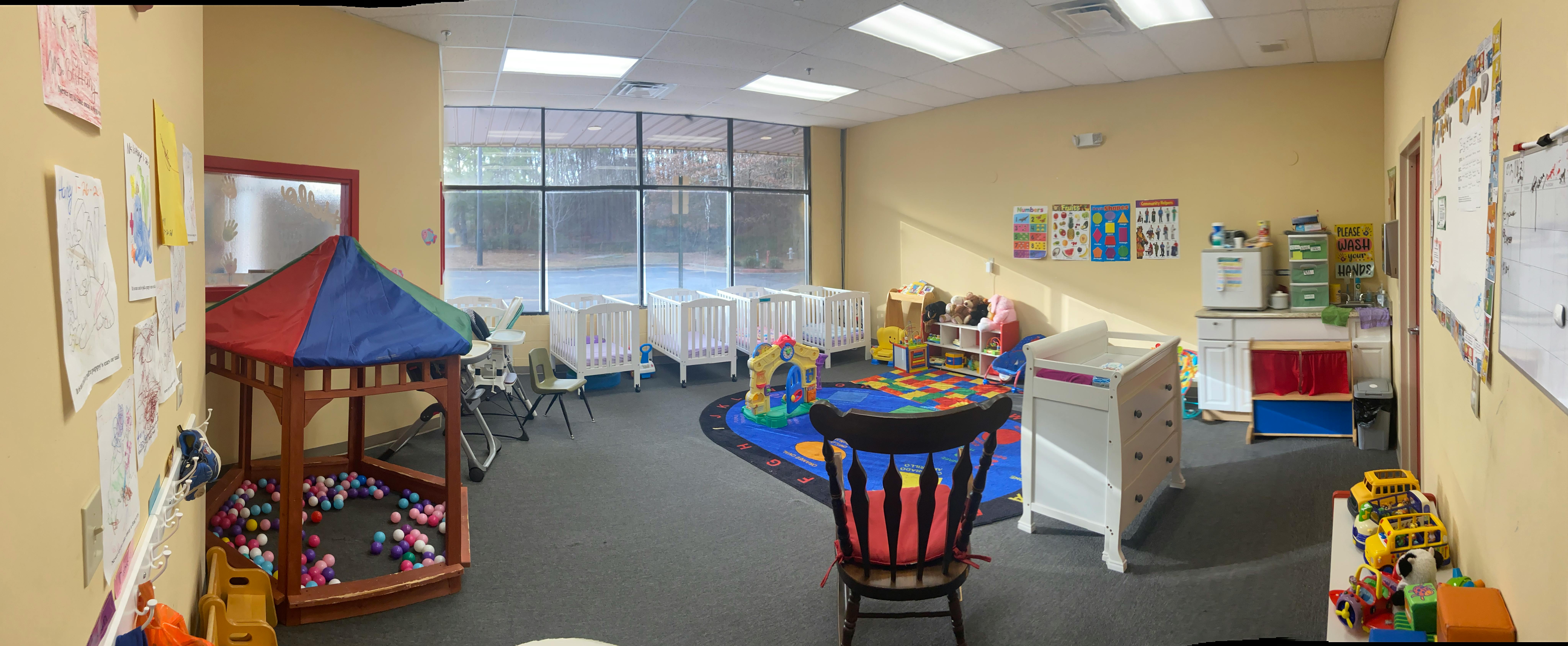 Playroom with cribs, play mat, and ball pit