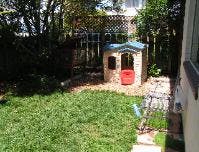 Backyard with a small playhouse and green grass