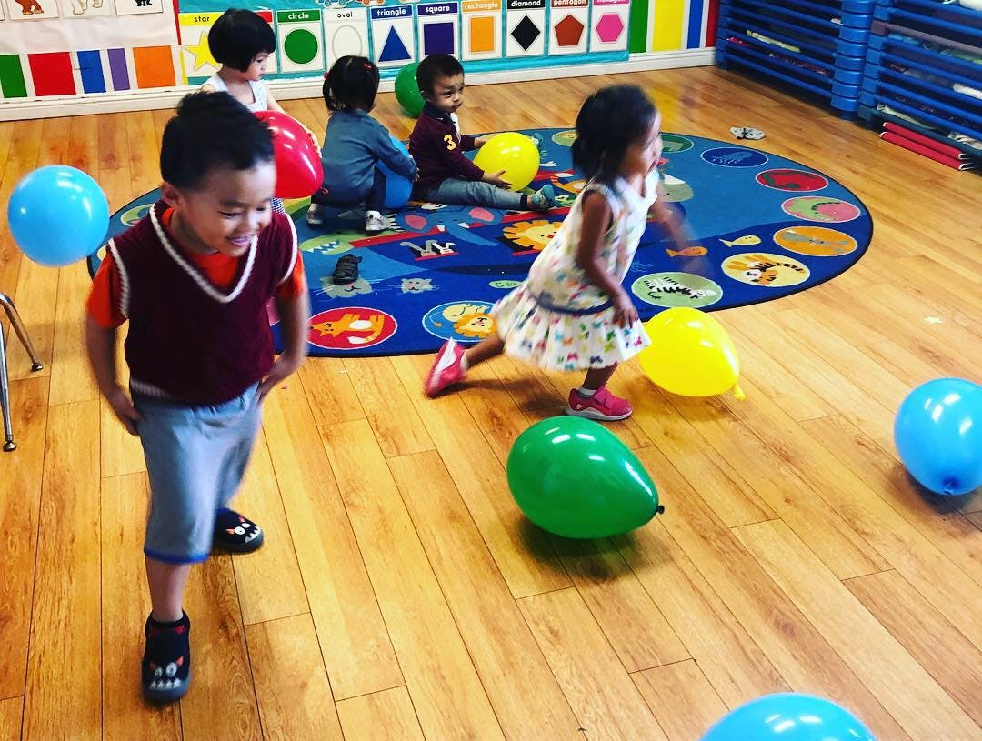 Children playing with balloons in a classroom